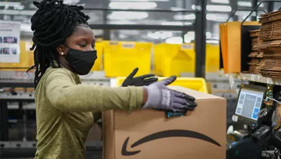 An amazon employee boxing products to ship