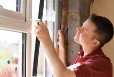 An installer fits a window into place