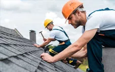 Roofers nail in shingles