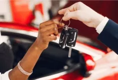 A car salesman handing over keys to a new car