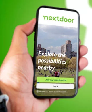 A person holding a mobile phone with the nextdoor app on it
