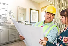 A contractor shows blueprints to a client