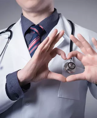 A doctor creates a heart sign with his hands